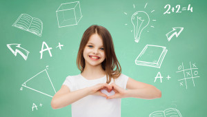 advertising, gesture, charity, education and people - smiling little girl in white blank t-shirt showing heart-shape gesture over green board with doodles background